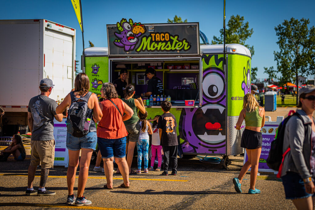 Customers lined up to order taco monster tacos in red deer alberta, in the summer