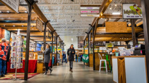 A woman walking through the Gasoline Alley Indoor Farmer's Market